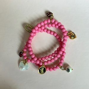 Pink stretch Juicy Couture charm bracelets.